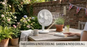 A rechargeable desk fan providing cooling on a wooden garden patio table during a sunny British summer afternoon, with lavender and Union Jack bunting in the background.