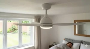 Reversible bedroom ceiling fan showing seasonal airflow patterns for summer cooling and winter heat recovery in a UK bedroom.