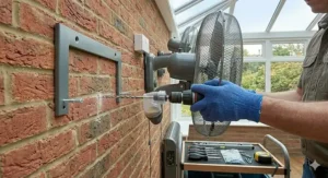 Installation guide diagram showing bracket mounting points and safe fixing heights for a wall fan in a home extension.