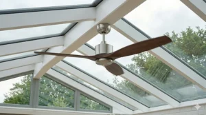 An innovative, quiet bladeless tower fan standing in the corner of a contemporary glass conservatory extension.