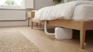 Compact bed cooling unit tucked discreetly away beside a modern UK bed frame, saving valuable floor space in a smaller bedroom.
