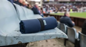 Lightweight stadium cushion rolled up neatly, showing how easily it fits into a backpack.
