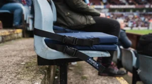 Adjustable fastening straps on the back of an affordable stadium seat cushion to prevent slipping.