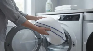 A zipped, removable pillow cover being placed into a washing machine for easy home laundering.