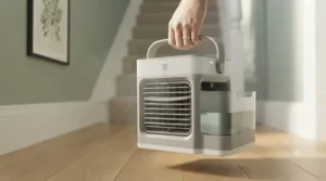 Lightweight personal air cooler with an integrated carry handle being moved between rooms in a British house.