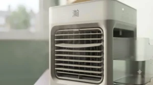 Close-up of an oscillating small air cooler showing adjustable louvres and speed settings for optimal airflow.