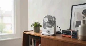 A stylish, minimalist USB-C desk fan placed on a living room bookshelf to complement modern interior decor