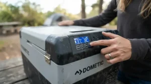 A person checking the digital temperature control on a battery powered cooler for camping.